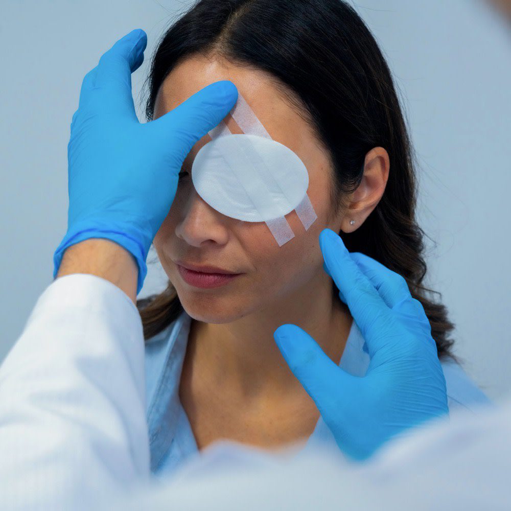 A woman with an eye patch being examined by a doctor.